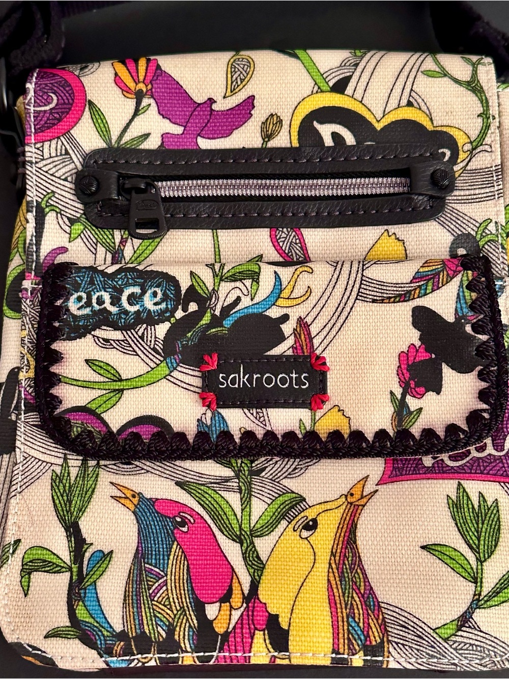 Sakroots Multicolor Floral Bird Canvas Crossbody Bag with the Peace Print motif.